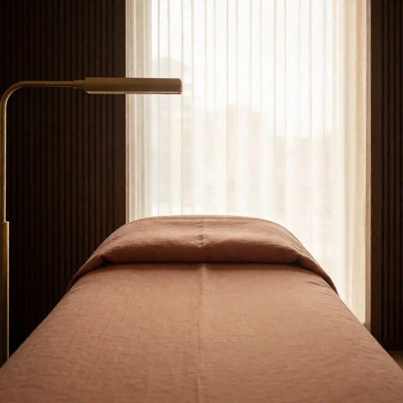 Afternoon light across a made treatment bed